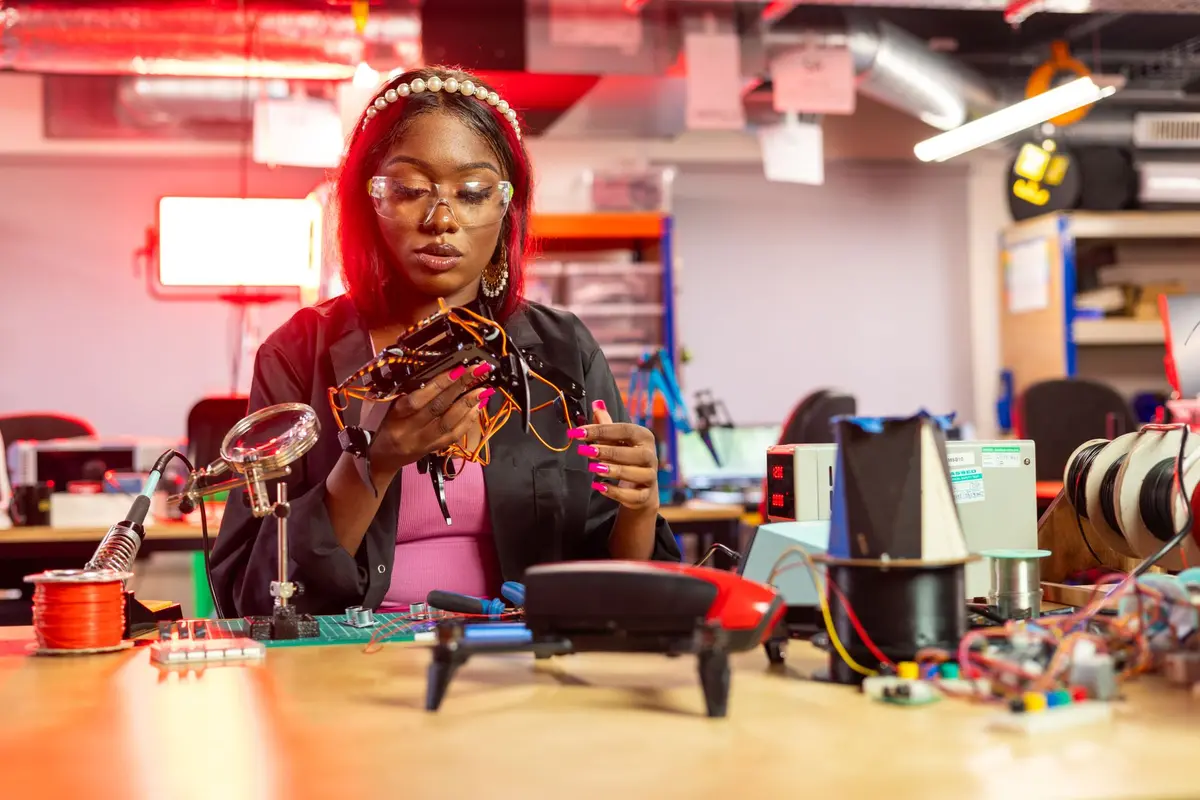 A young engineer assembling a drone in a workshop.