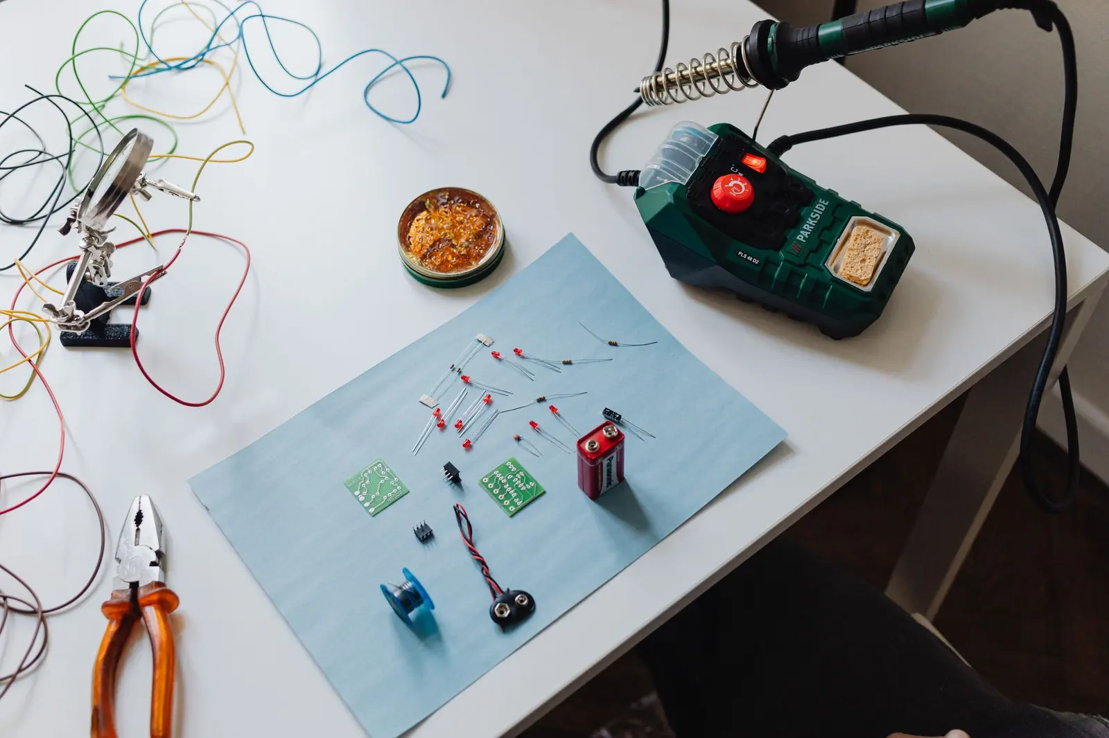 A workbench with electronic parts and small tools laid out.