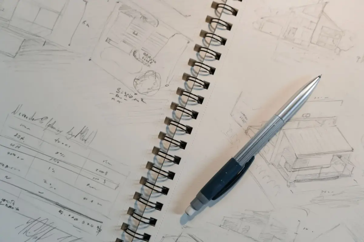 A notebook with sketches and planning notes on a desk.