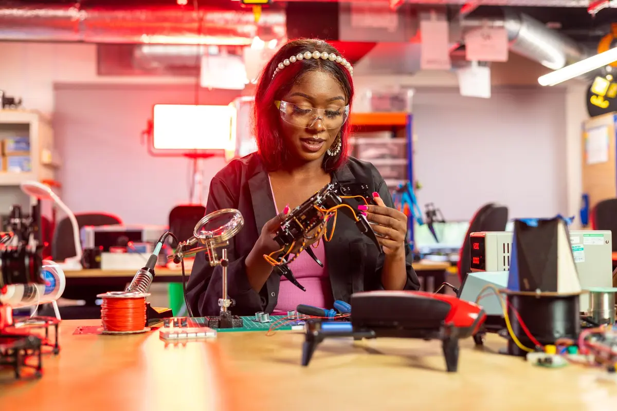 A young engineer examining a drone frame at a workbench.